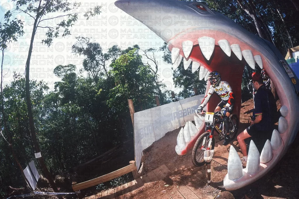 NICOLAS VOUILLOZ (MENS WINNER PICTURED) E OTHER DOWNHILL COMPETITORS STARTED FROM INSIDE THE JAWS OF A GIANT SHARK AT CAIRNS, AUSTRALIA. UCI CAMPIONATI DEL MONDO 1996