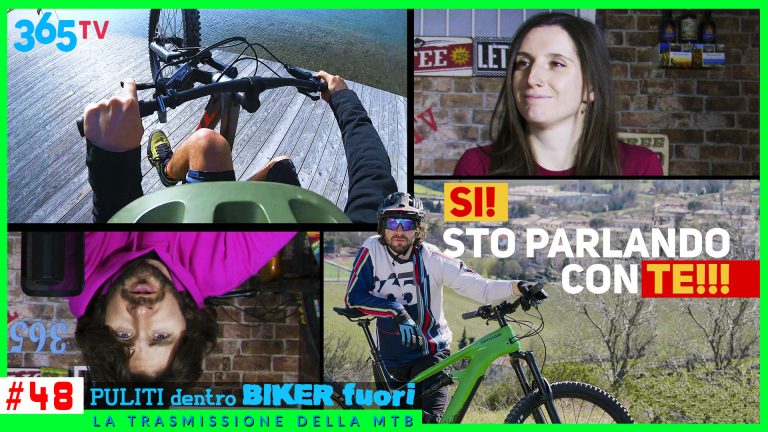 Primo piano di un ciclista con casco e occhiali da sole in un ambiente naturale.