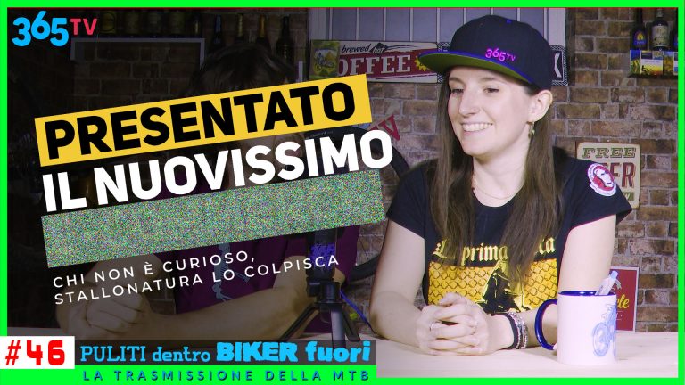 Ragazza sorridente con cappello 365TV, davanti sfondo con mattoni e decorazioni da bar.