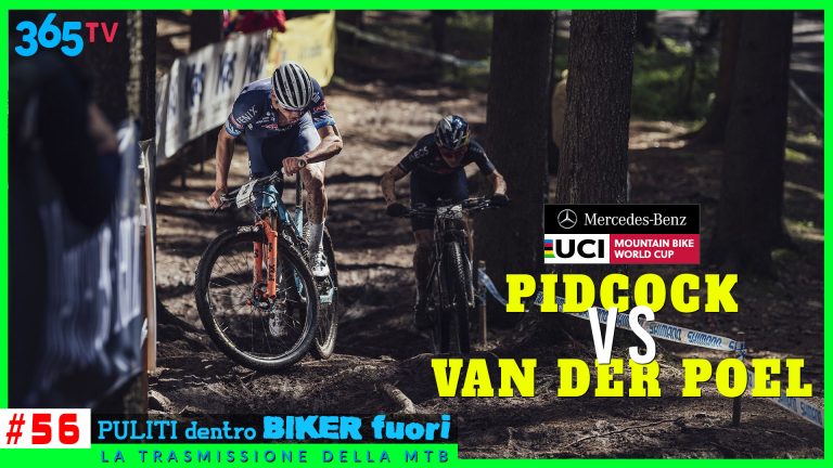 Azione di mountain bike in gara tra alberi, con due ciclisti intensamente concentrati.