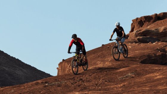 Eroe del mountain bike su percorso roccioso al tramonto.