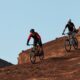 Eroe del mountain bike su percorso roccioso al tramonto.