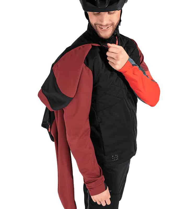 Zaino da mountain bike e abbigliamento tecnico, biker sorridente in posa.