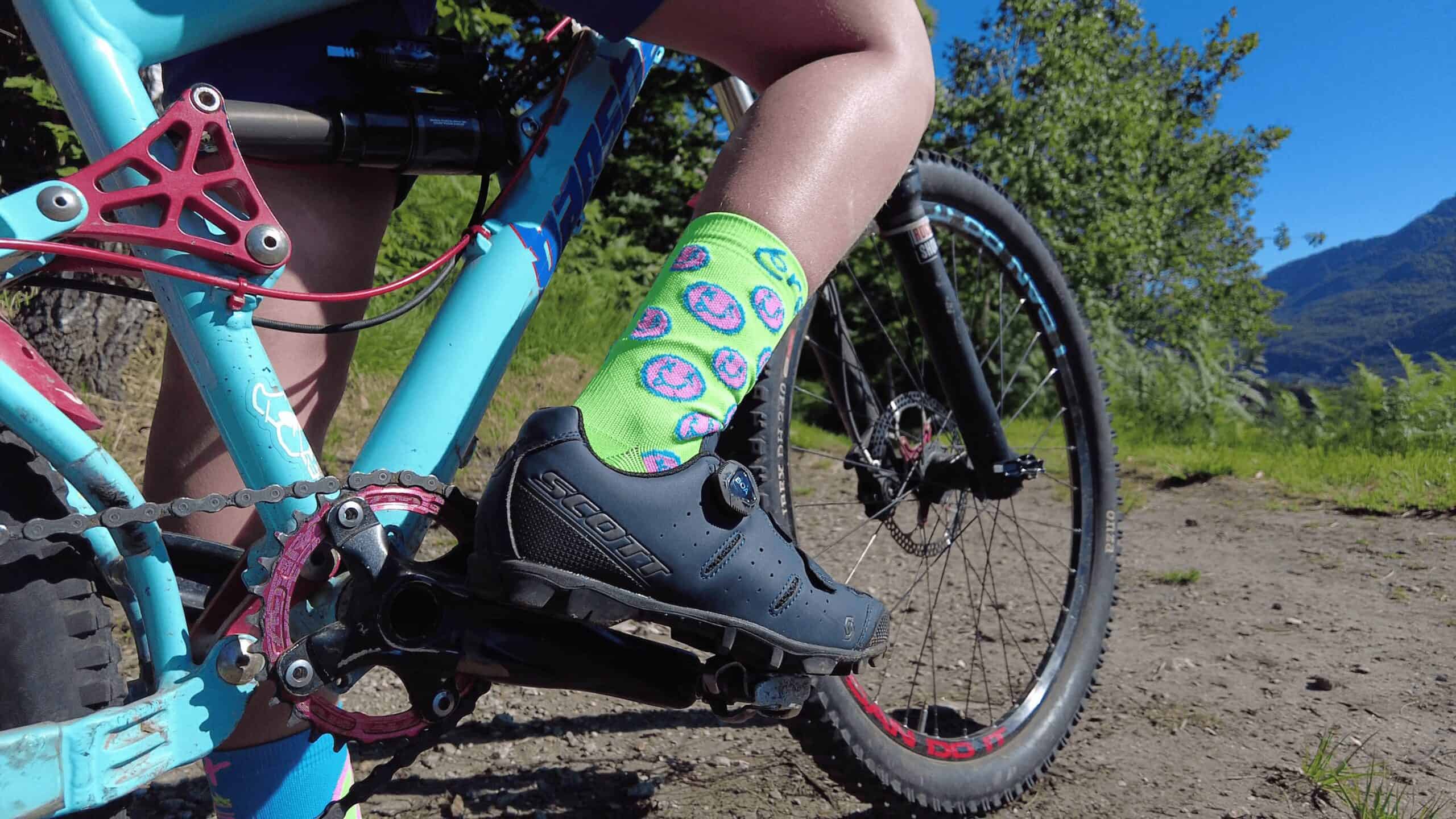 Scarpa da mountain bike e calze colorful su un sentiero in montagna.