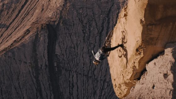Ciclista in discesa su un sentiero di roccia in un canyon spettacolare.