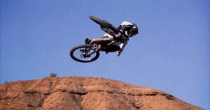 Salto in mountain bike su terreni rocciosi con stunt acrobatici.