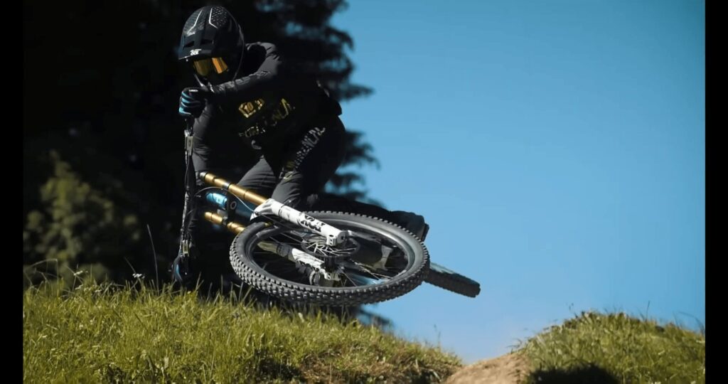 Ciclista in mountain bike su terreni accidentati, caduta spettacolare in un percorso di trail.