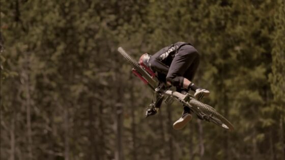 Salto in Mountain Bike su terreno naturale con il ciclista in aria.