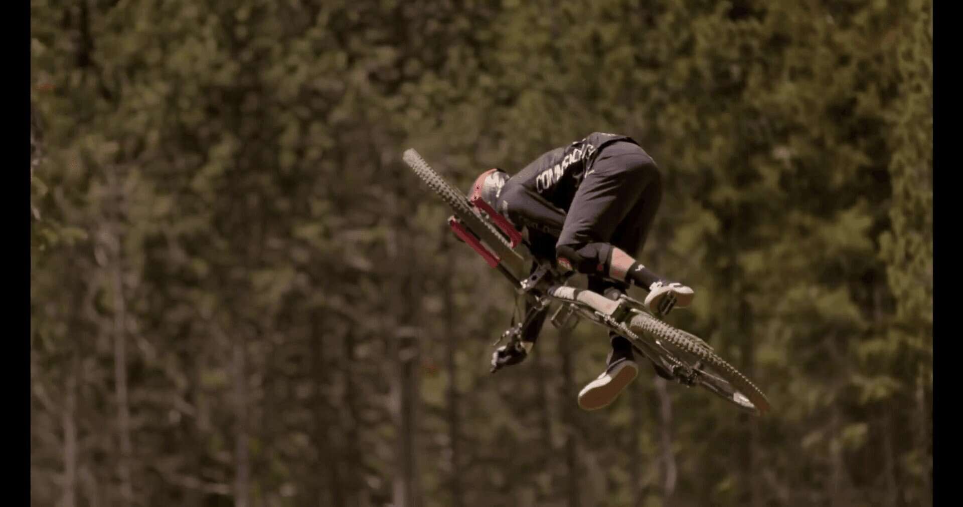 Salto in Mountain Bike su terreno naturale con il ciclista in aria.