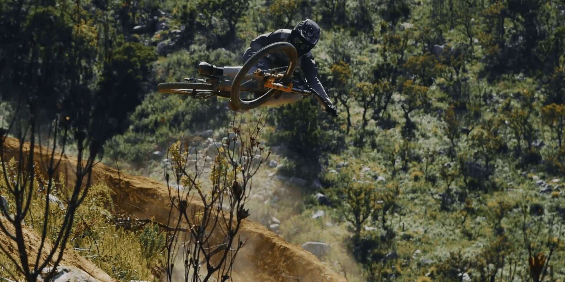 1. Mountain biker in mid-air jump on mountain trail.