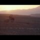 Schiacciata da una motocross su un paesaggio desertico al tramonto.