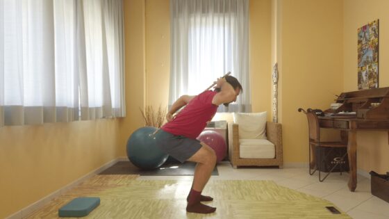 Allenamento casalingo con palla medica e bastone, esercizi di fitness indoor.