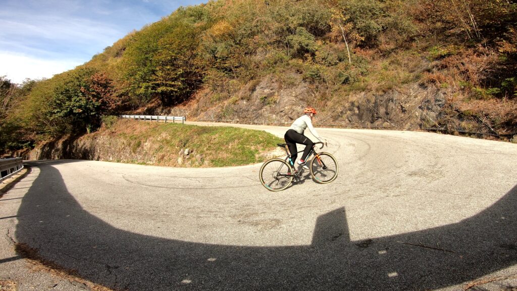 Ciclista su curva di montagna in fotografia all'aperto.