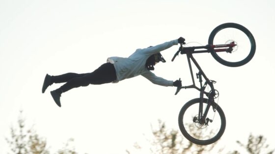 Adrenalina e abilità: ciclista in volo con mountain bike durante spettacolare salto.