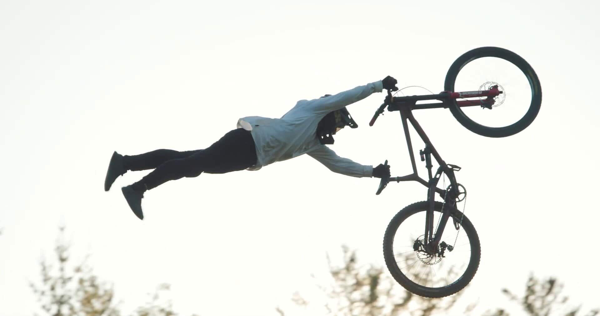 Adrenalina e abilità: ciclista in volo con mountain bike durante spettacolare salto.