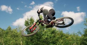 Sospensione in aria durante una sessione di downhill mountain biking in natura.