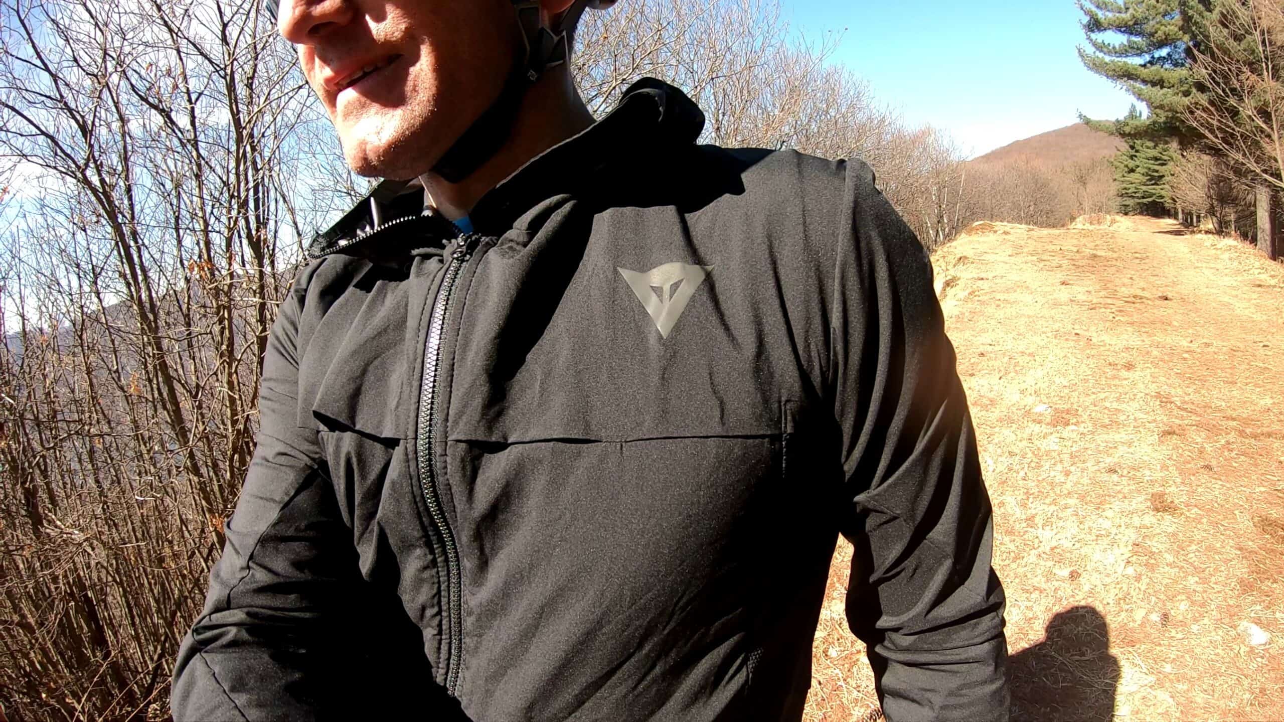 Avventura in mountain bike in un bosco con sentiero sterrato e paesaggio montano.