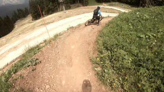 VTT in curva su sentiero sterrato tra natura e vegetazione.