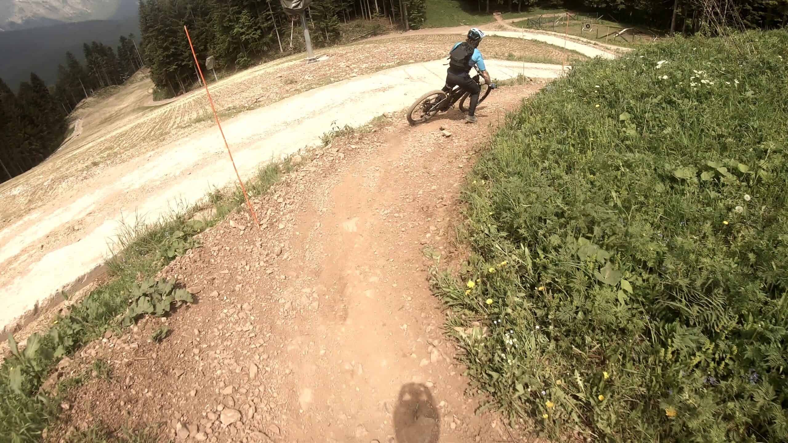 VTT in curva su sentiero sterrato tra natura e vegetazione.