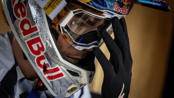 Casco da motocross Red Bull con visiera, dettagli glitterati e logo Red Bull, in primo piano.