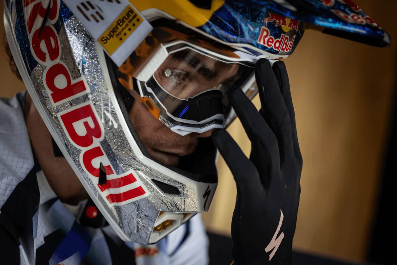 Casco da motocross Red Bull con visiera, dettagli glitterati e logo Red Bull, in primo piano.