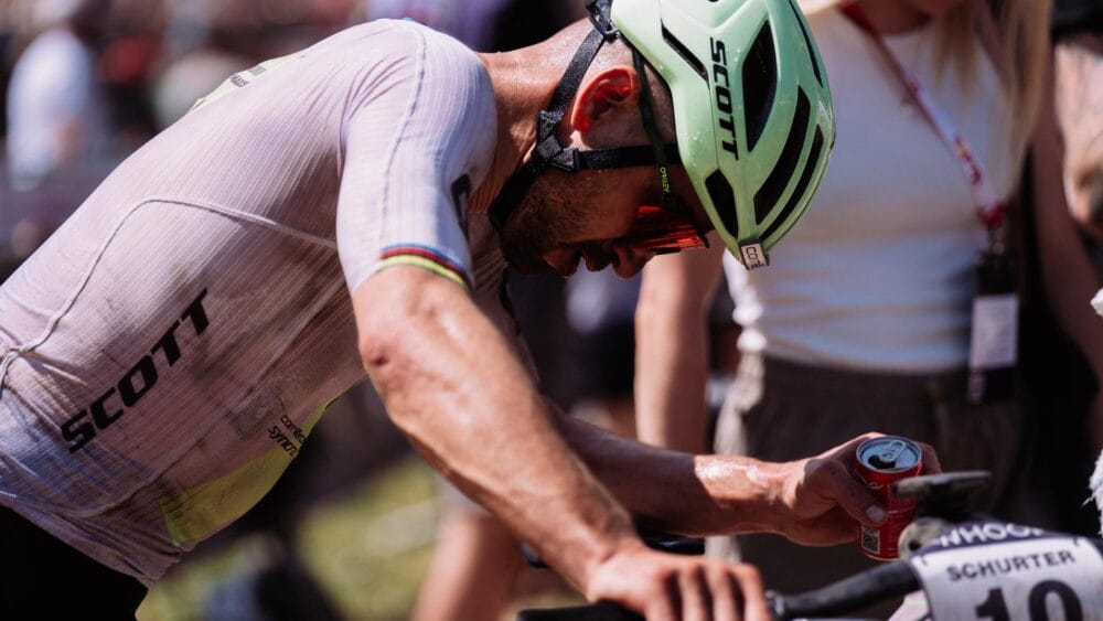 Ciclista con casco e maglia in gara, si prepara per la competizione di mountain bike.