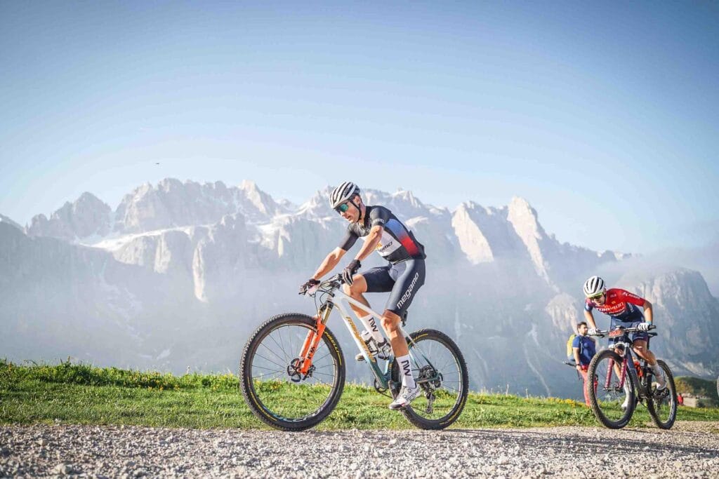 Pedale su montagna con ciclisti in cima alle Dolomiti italiane, paesaggi mozzafiato e sport all'aperto.