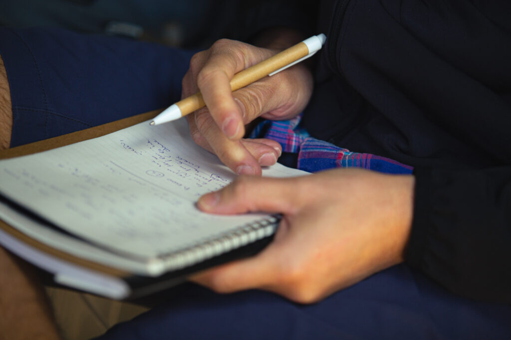Appunti di viaggio con penna e quaderno, apprezzando le attività all'aperto e la passione per il ciclismo.