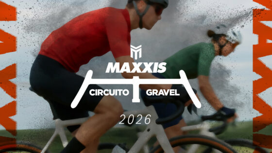 Velo da corsa in condizioni di pioggia, due ciclisti in gara sulla strada bagnata con spray d'acqua.