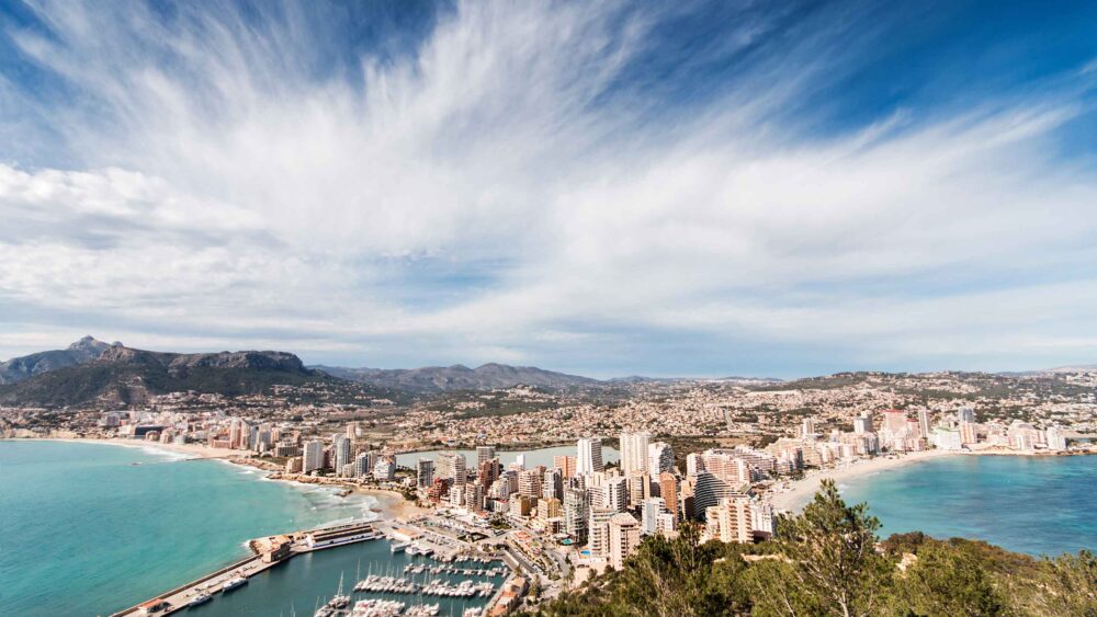 Ville costiere con grattacieli e porto, vista panoramica della città e mare brillante.