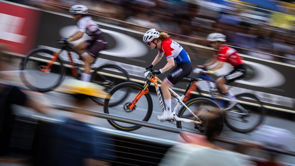 Ciclisti in azione durante una competizione di mountain bike su un percorso impegnativo.